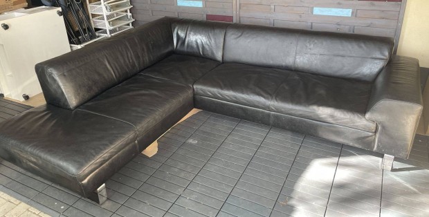 Andante fekete L alakú bőrkanapé görgős puffal