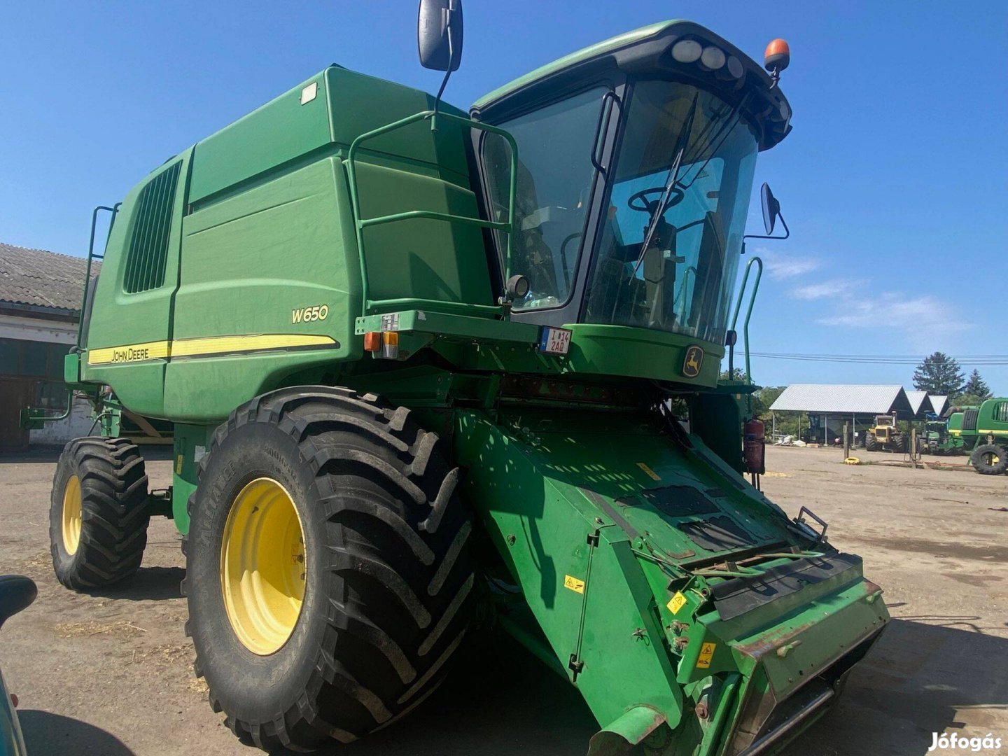 John Deere W650 kombájn gabonaasztallal, szállítókocsival
