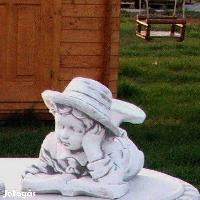 Kerti figura fekvő könyves fiú