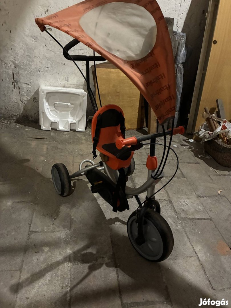 Narancssárga, tetővel ellátott gyerek háromkerekű,