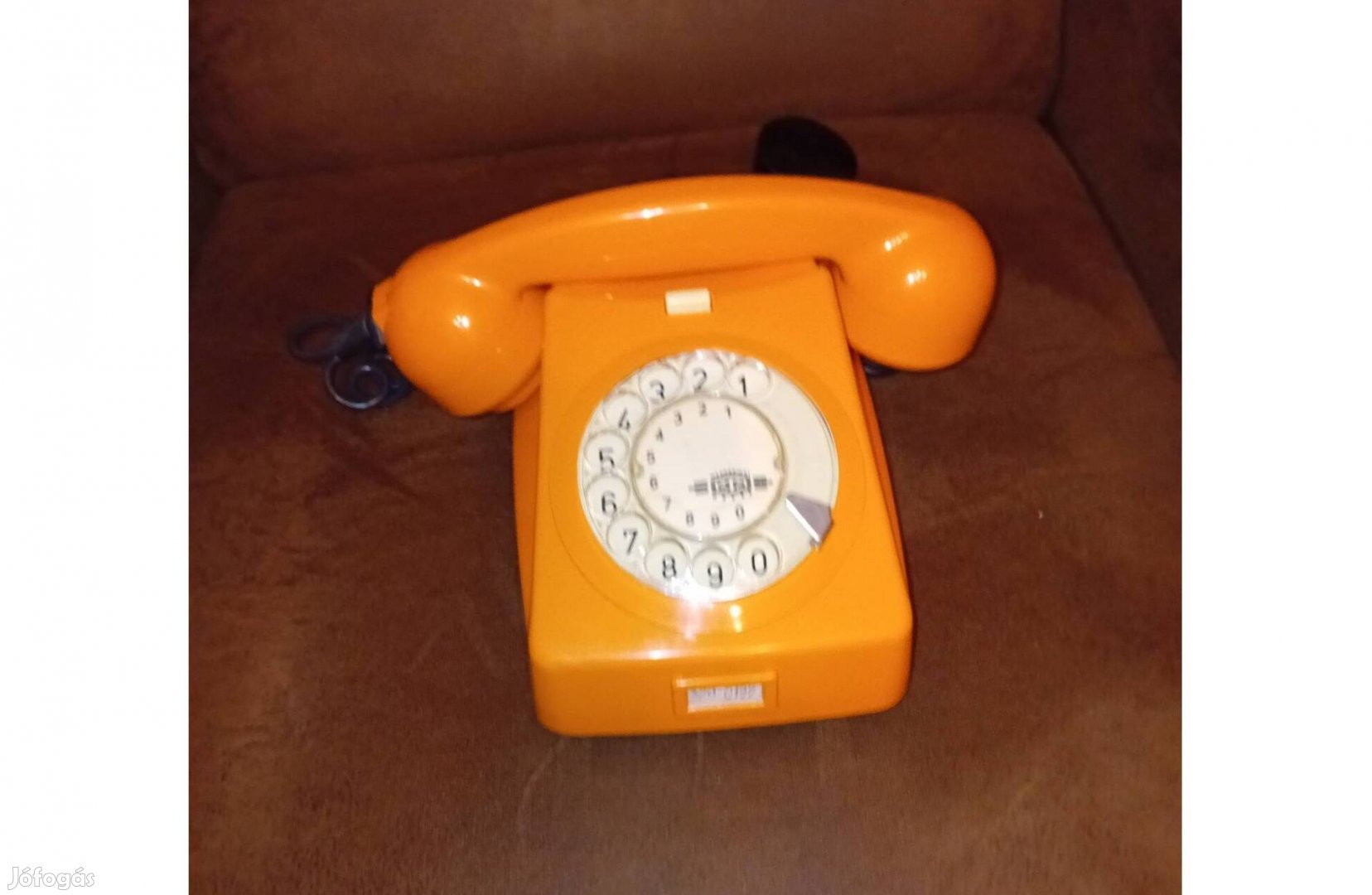 Régi , retro de új állapotú vezetékes , tárcsás narancssárga telefon