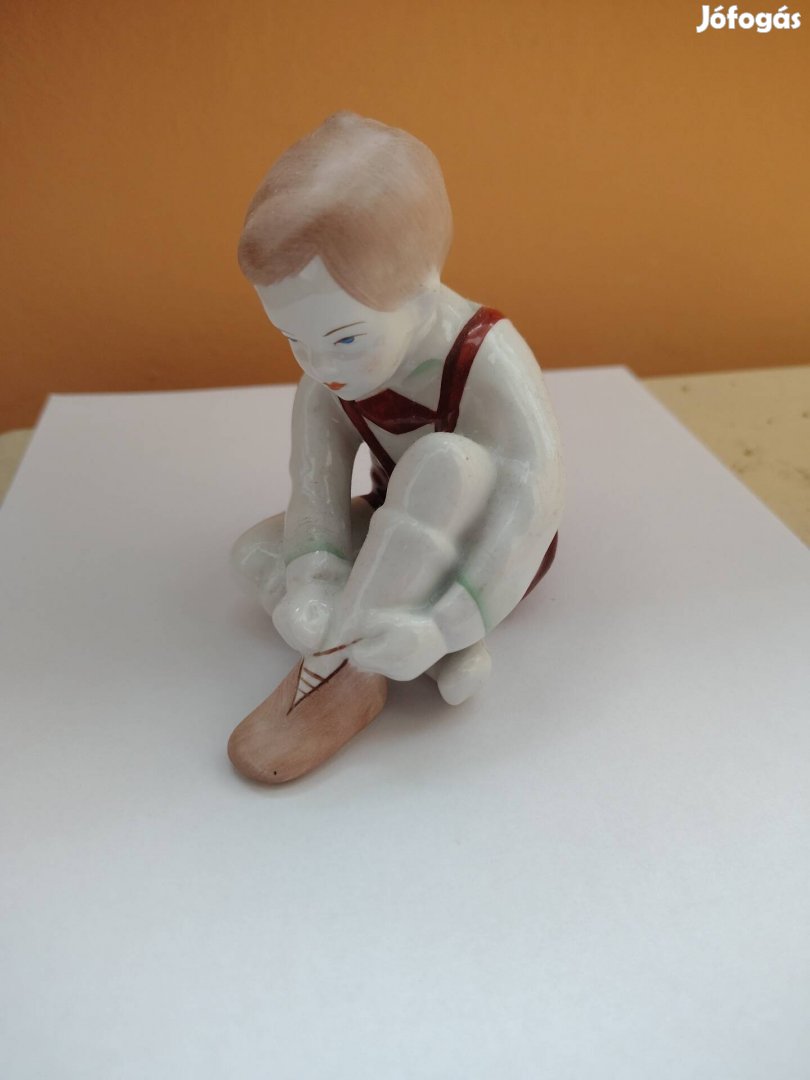 porcelán cipőt fűző fiú