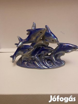 Egy csoport delfin, amint hullámokon ugrálnak.