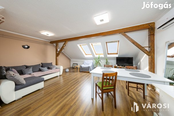 Látszó fagerendás tetőtéri lakás csendes utcában