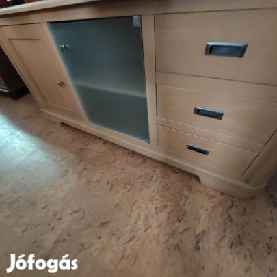 Világos színű fiókos ajtós komód.