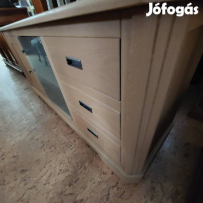 Világos színű fiókos ajtós komód.